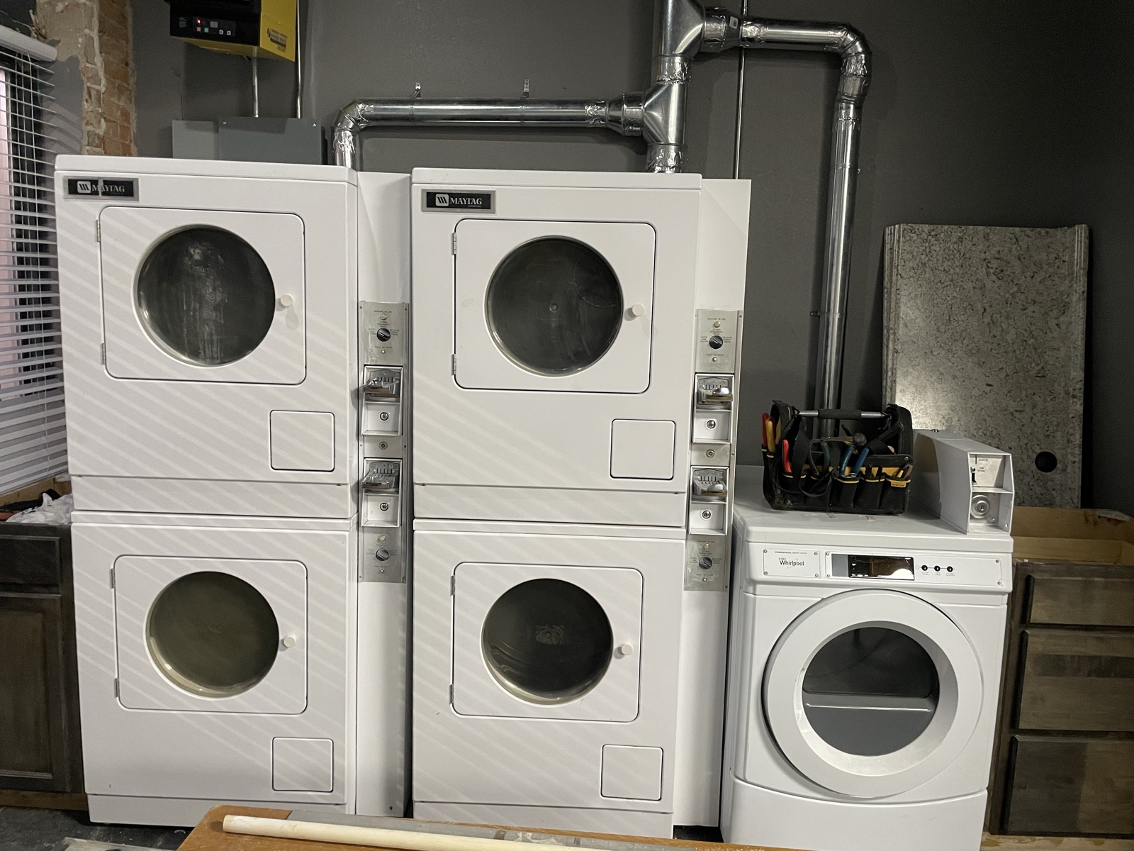 Stacked commercial dryers along the wall